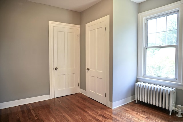 575 S Main St, Naugatuck, CT 06770 - unfurnished bedroom featuring radiator, multiple windows, and wood finished floors