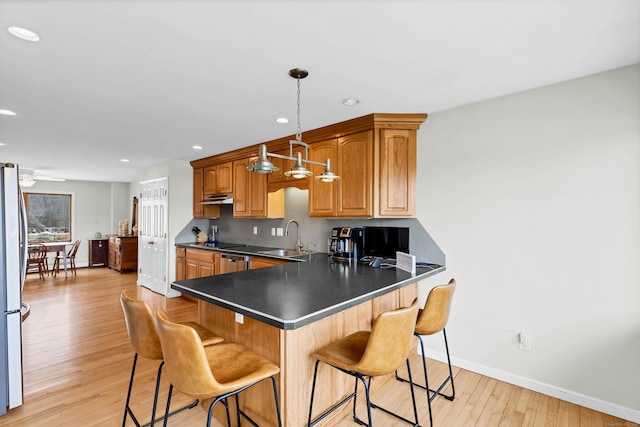 224 Neptune Dr, Groton, CT 06340 - kitchen featuring light wood finished floors, baseboards, a sink, a kitchen bar, and recessed lighting