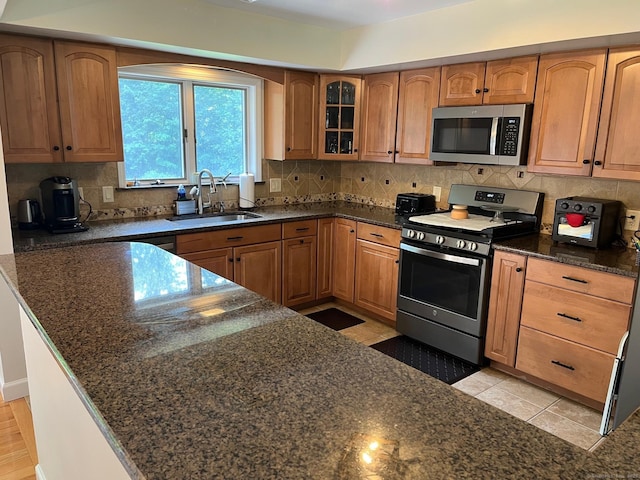 15 Great Meadow Rd, Danbury, CT 06811 - kitchen featuring stainless steel appliances, glass insert cabinets, dark stone countertops, backsplash, and brown cabinetry