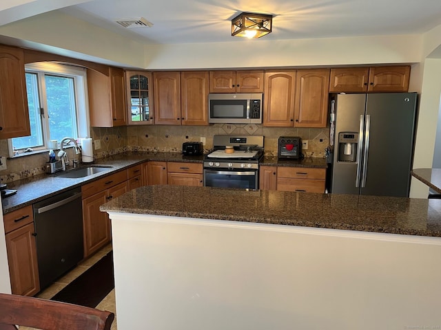 15 Great Meadow Rd, Danbury, CT 06811 - kitchen featuring appliances with stainless steel finishes, brown cabinets, decorative backsplash, and dark stone countertops