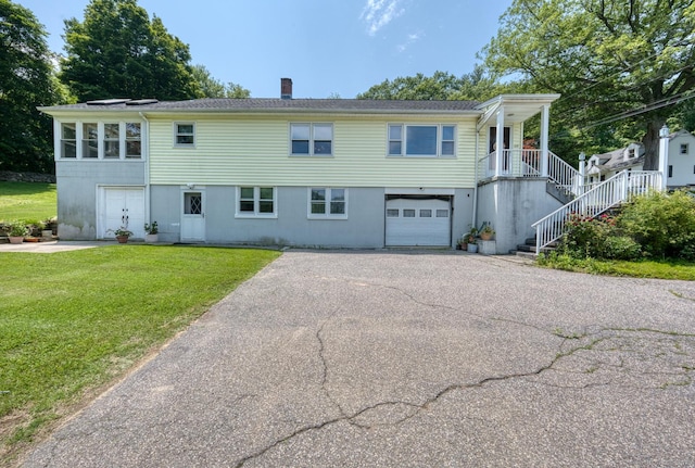 135 Jackson St, Torrington, CT 06790 - view of front of property featuring asphalt driveway, stairs, a front yard, an attached garage, and a chimney