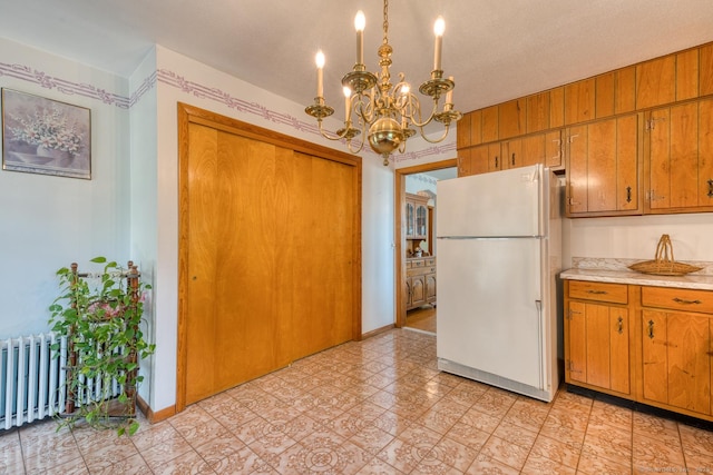 135 Jackson St, Torrington, CT 06790 - kitchen with freestanding refrigerator, a chandelier, light countertops, and brown cabinets