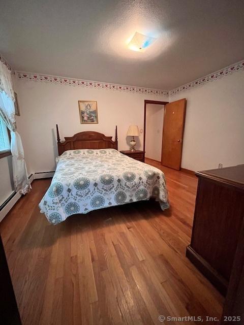 135 Jackson St, Torrington, CT 06790 - bedroom with wood finished floors and a baseboard radiator