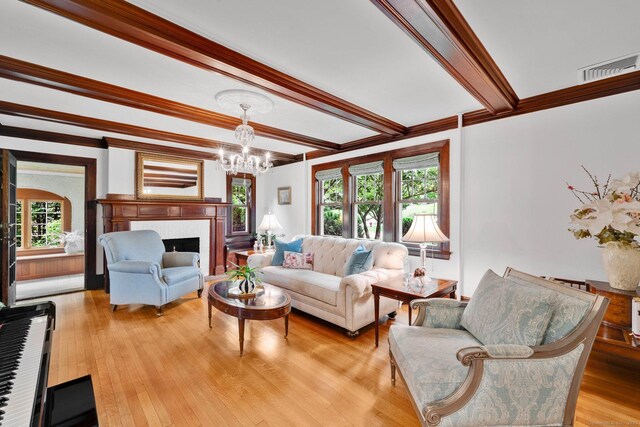 20 Arnoldale Rd, West Hartford, CT 06119 - living room featuring a chandelier, beam ceiling, ornamental molding, light wood-type flooring, and a fireplace