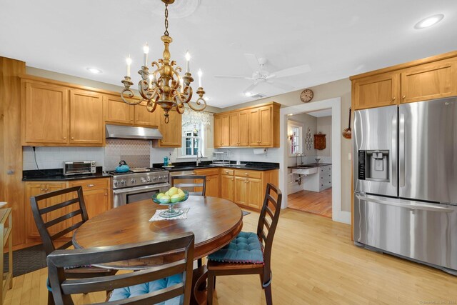 20 Arnoldale Rd, West Hartford, CT 06119 - kitchen featuring stainless steel appliances, under cabinet range hood, dark countertops, a sink, and light wood-style floors