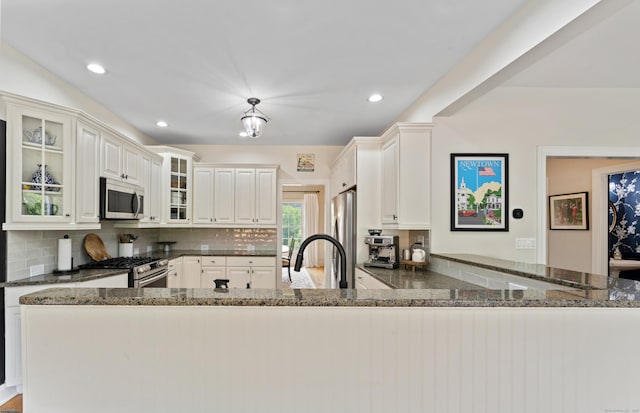 11 Quarry Ridge Rd, Newtown, CT 06482 - kitchen featuring appliances with stainless steel finishes, tasteful backsplash, dark stone counters, glass insert cabinets, and recessed lighting
