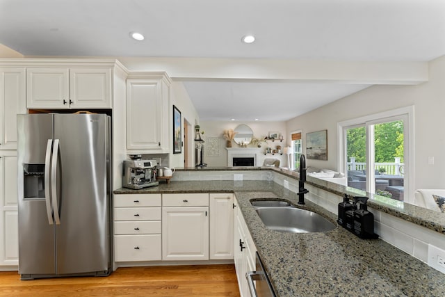 11 Quarry Ridge Rd, Newtown, CT 06482 - kitchen featuring appliances with stainless steel finishes, dark stone counters, a fireplace, light wood-style floors, and recessed lighting