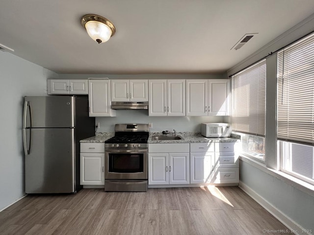 87 Blake St, New Haven, CT 06511 - kitchen featuring stainless steel appliances, under cabinet range hood, white cabinets, and light wood finished floors
