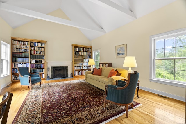 102 Leetes Island Rd, Guilford, CT 06437 - living room featuring healthy amount of natural light, wood finished floors, a fireplace with flush hearth, and high vaulted ceiling