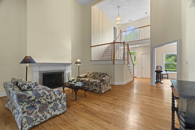 102 Leetes Island Rd, Guilford, CT 06437 - living area featuring a high ceiling, wood finished floors, stairs, baseboards, and a fireplace