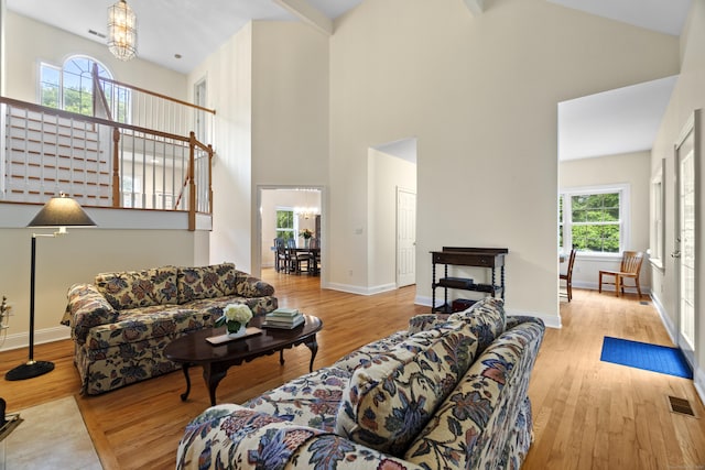 102 Leetes Island Rd, Guilford, CT 06437 - living area with a chandelier, high vaulted ceiling, wood finished floors, and baseboards