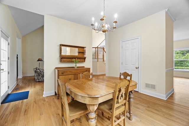 102 Leetes Island Rd, Guilford, CT 06437 - dining room featuring light wood-type flooring, a chandelier, stairs, and vaulted ceiling