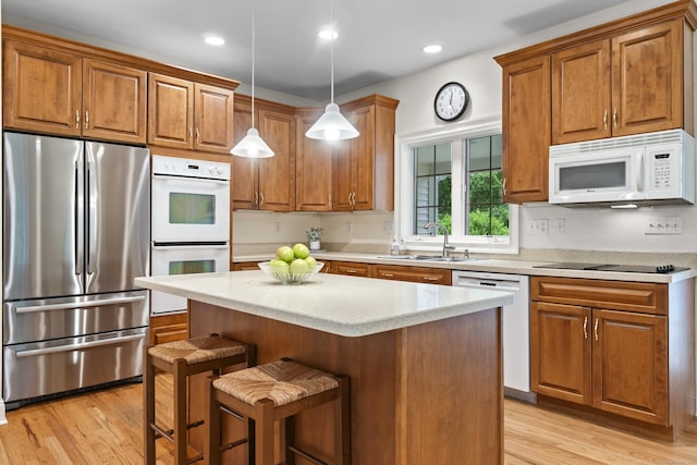 102 Leetes Island Rd, Guilford, CT 06437 - kitchen featuring white appliances, a sink, brown cabinets, light wood-style flooring, and recessed lighting