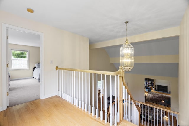 102 Leetes Island Rd, Guilford, CT 06437 - hallway featuring an upstairs landing, wood finished floors, a chandelier, and baseboards