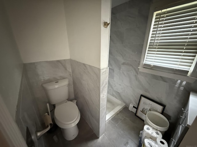 6 Sandra Dr, Bloomfield, CT 06002 - bathroom featuring tile walls, toilet, a stall shower, and tile patterned floors