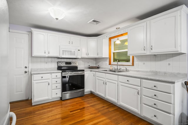 38 Fairfield Rd, Enfield, CT 06082 - kitchen with electric range, white microwave, white cabinetry, and tasteful backsplash