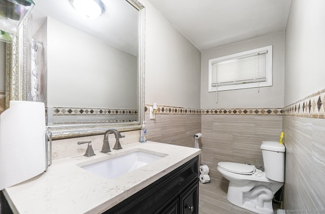 bathroom with tile walls, vanity, and a wainscoted wall