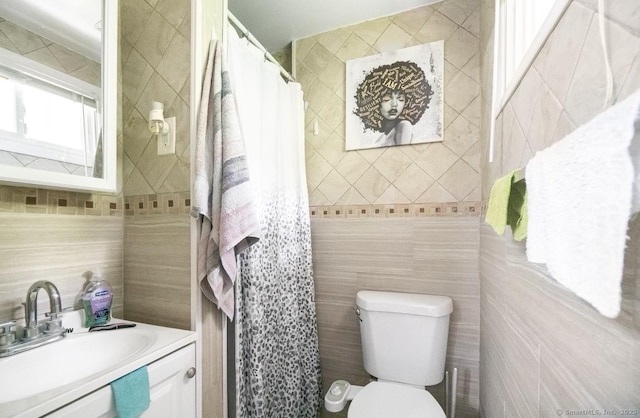 bathroom featuring tile walls, vanity, and curtained shower