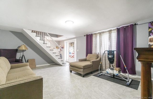 living room featuring stairs and baseboards