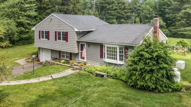 128 Walnut Tree Hill Rd, Newtown, CT 06482 - split level home featuring a chimney, a front yard, an attached garage, a forest view, and roof with shingles