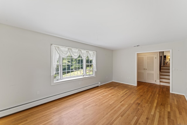 128 Walnut Tree Hill Rd, Newtown, CT 06482 - empty room with a baseboard heating unit, light wood-style floors, and stairway