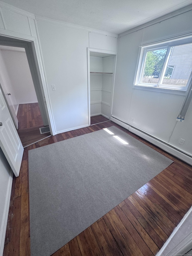 61 Naubuc Ave, East Hartford, CT 06118 - unfurnished bedroom with dark wood-style floors, a closet, and baseboard heating
