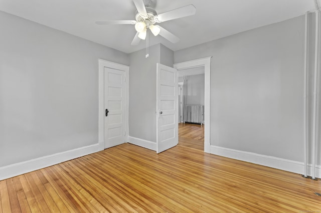 471 New Britain Rd, Berlin, CT 06037 - spare room featuring radiator heating unit, a ceiling fan, and light wood-style flooring