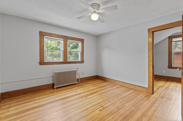 471 New Britain Rd, Berlin, CT 06037 - empty room featuring radiator heating unit, light wood-type flooring, a ceiling fan, and a textured ceiling