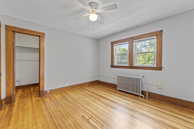 471 New Britain Rd, Berlin, CT 06037 - unfurnished bedroom featuring radiator, a textured ceiling, light wood-style flooring, a closet, and a ceiling fan