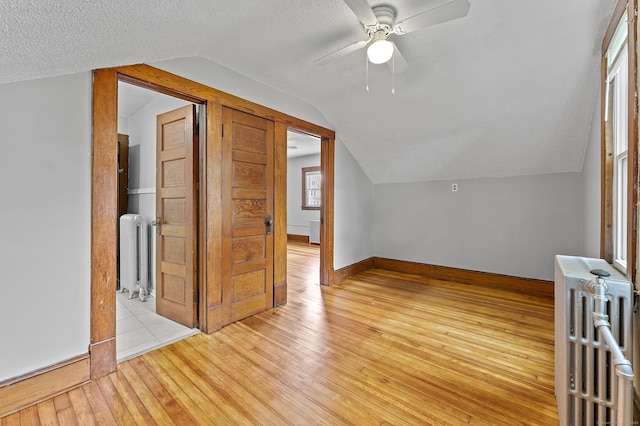 471 New Britain Rd, Berlin, CT 06037 - additional living space with radiator heating unit, vaulted ceiling, light wood-style floors, a ceiling fan, and a textured ceiling