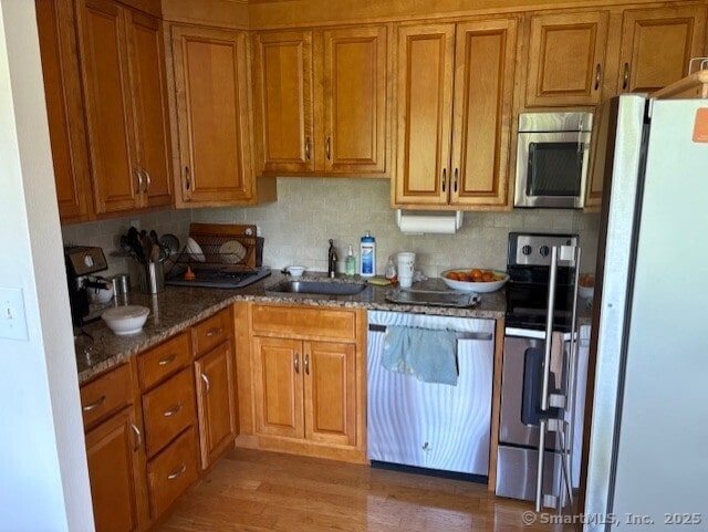 1310 Berlin Tpke Apt 525, Wethersfield, CT 06109 - kitchen featuring appliances with stainless steel finishes, brown cabinetry, and dark stone counters