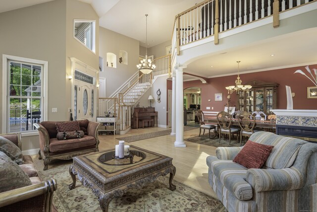 1729 Litchfield Rd, Watertown, CT 06795 - living room featuring arched walkways, a chandelier, a high ceiling, stairway, and decorative columns
