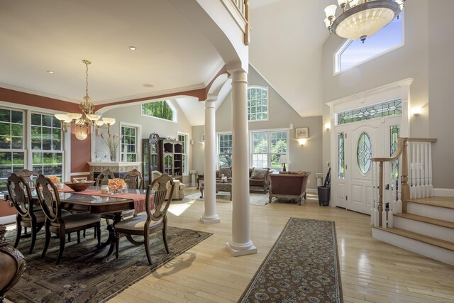 1729 Litchfield Rd, Watertown, CT 06795 - dining area with decorative columns, a chandelier, light wood-style floors, and a towering ceiling