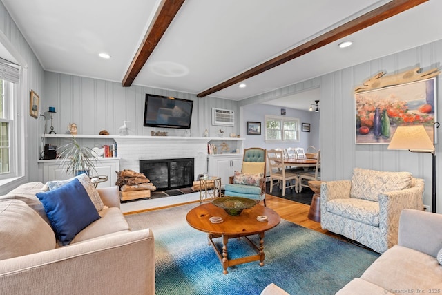 52 Seaside Ave, Guilford, CT 06437 - living room featuring wood finished floors, beamed ceiling, a brick fireplace, a decorative wall, and recessed lighting