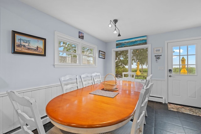 52 Seaside Ave, Guilford, CT 06437 - dining room featuring baseboard heating, a wainscoted wall, dark tile patterned floors, and a decorative wall
