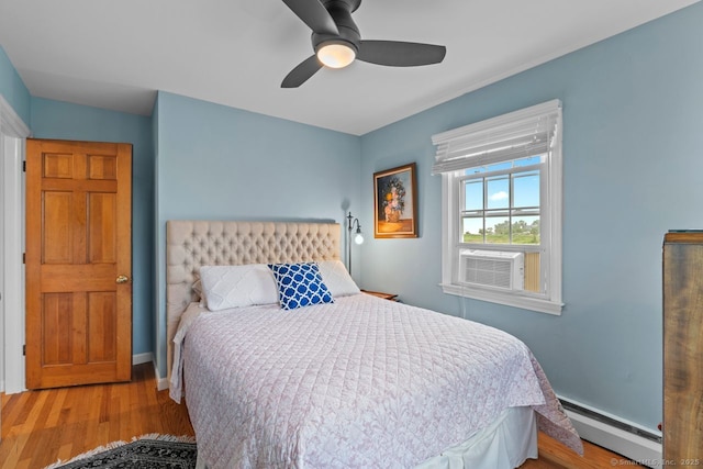 52 Seaside Ave, Guilford, CT 06437 - bedroom featuring baseboard heating, cooling unit, wood finished floors, and ceiling fan
