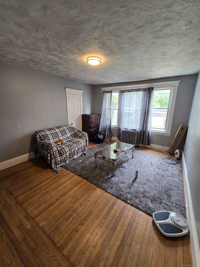 516 Dixwell Ave, New Haven, CT 06511 - living area with wood-type flooring, radiator, and a textured ceiling
