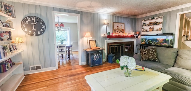 4 Tryon Rd, Norwalk, CT 06851 - living area with ornamental molding, wood finished floors, a textured ceiling, and a fireplace with flush hearth