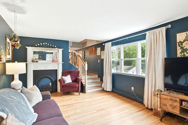 95 Lauter Ave, Windham, CT 06226 - living room featuring stairs, a fireplace, wood finished floors, and a baseboard heating unit