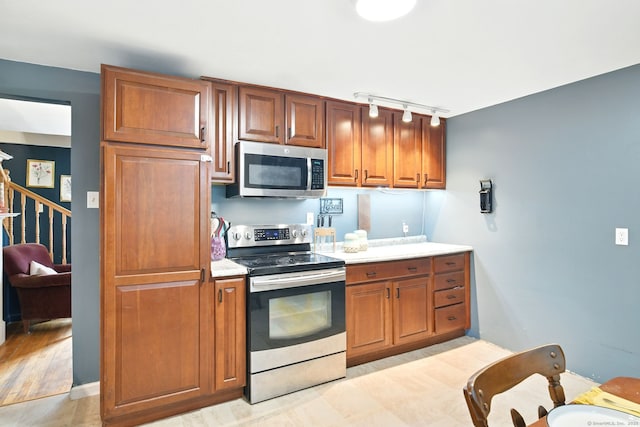 95 Lauter Ave, Windham, CT 06226 - kitchen featuring stainless steel appliances, track lighting, light countertops, and brown cabinetry