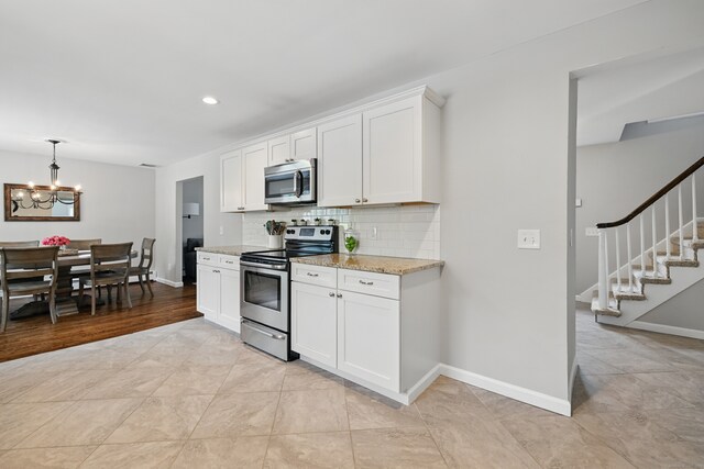 197 Webb Rd, Naugatuck, CT 06770 - kitchen featuring stainless steel appliances, a chandelier, backsplash, white cabinetry, and light stone countertops