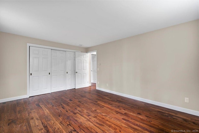 41 Cedarhurst Ln, Milford, CT 06461 - unfurnished bedroom featuring baseboards, dark wood-style flooring, and a closet