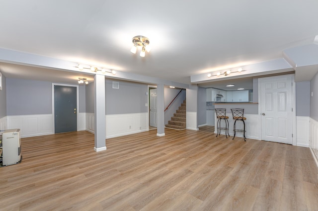 30 Lewis Rd, Bristol, CT 06010 - finished below grade area with a wainscoted wall, stairs, light wood finished floors, and bar