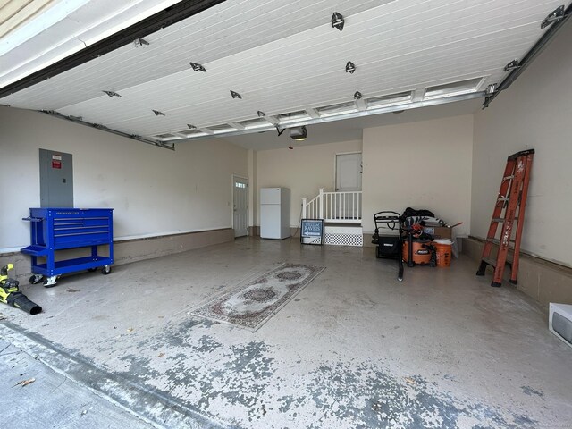 756 Hart St, Bridgeport, CT 06606 - garage featuring freestanding refrigerator, a garage door opener, and electric panel