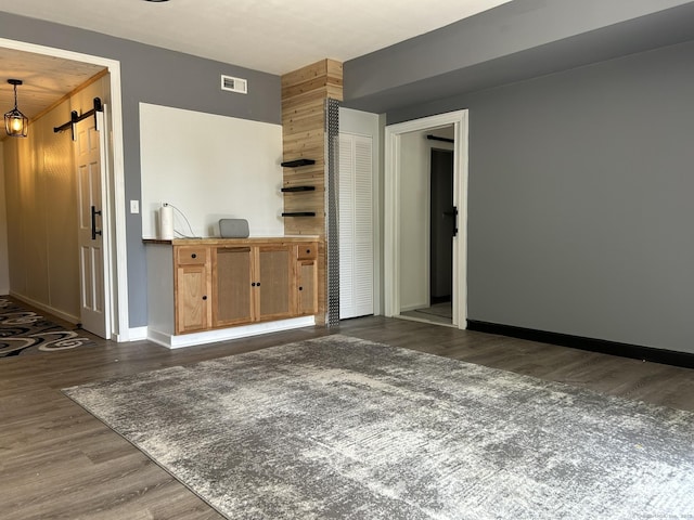 756 Hart St, Bridgeport, CT 06606 - unfurnished living room with dark wood-style flooring and a barn door