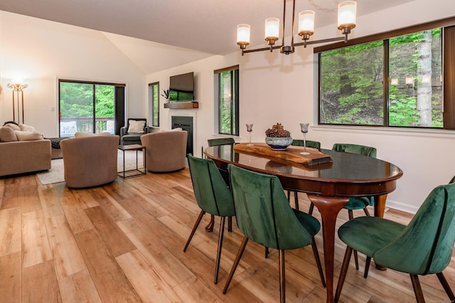 11 Wood Duck Ln Unit 11, Simsbury, CT 06081 - dining area with a chandelier, light wood finished floors, lofted ceiling, and a fireplace