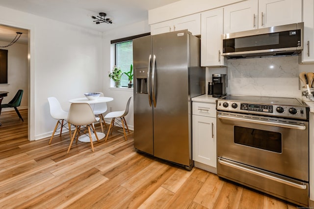 11 Wood Duck Ln Unit 11, Simsbury, CT 06081 - kitchen featuring appliances with stainless steel finishes, white cabinets, decorative backsplash, and light wood-type flooring