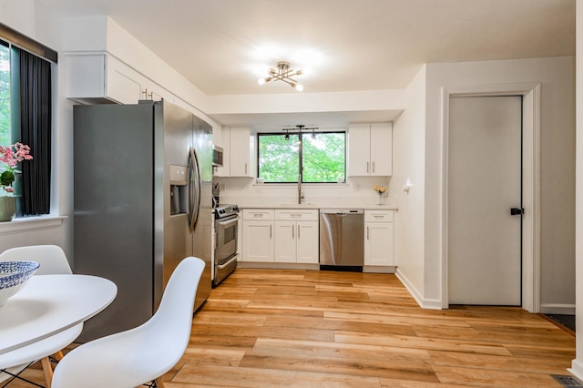 11 Wood Duck Ln Unit 11, Simsbury, CT 06081 - kitchen featuring stainless steel appliances, white cabinetry, light wood finished floors, and light countertops