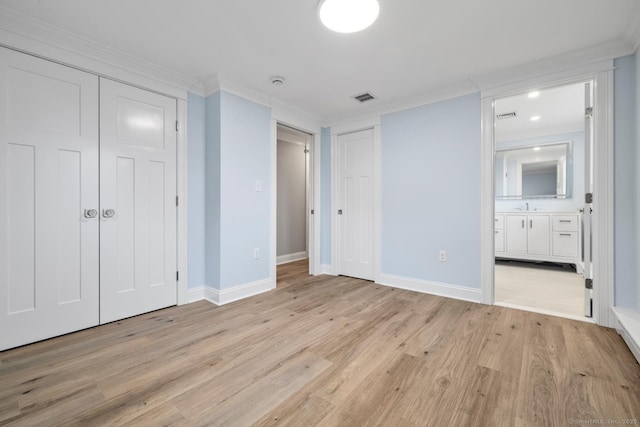 8 Edwards Rd, Old Saybrook, CT 06475 - unfurnished bedroom with light wood finished floors, crown molding, connected bathroom, and two closets