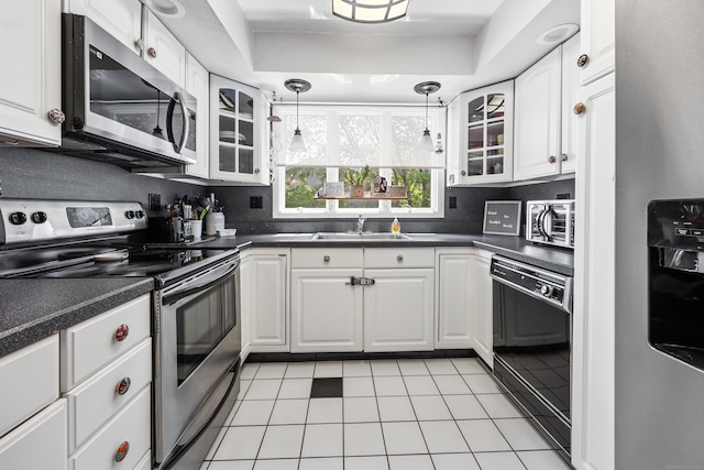 30 S Dale St, East Haven, CT 06513 - kitchen with appliances with stainless steel finishes, light tile patterned floors, dark countertops, and glass insert cabinets